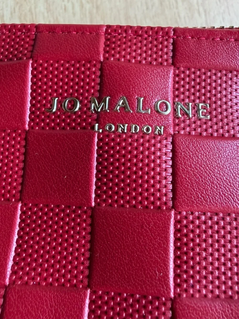 Jo Malone London cosmetic bag features a vibrant red woven design